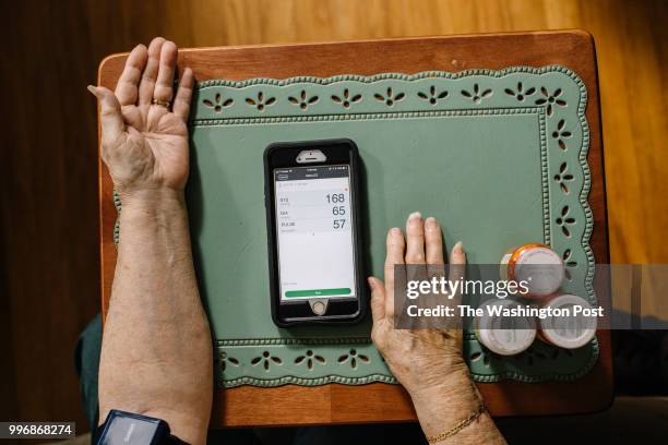 June 27: Ann Ware uses a Bluetooth-enabled blood pressure cuff provided to her by Oschner health care network. The device syncs with her smartphone,...