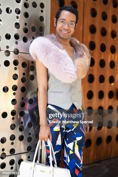 Kristopher Fraser is seen on the street during Men's New York Fashion Week wearing DVF fur, Brooks Brothers bag, YSL vest, Ralph Lauren pants on July...