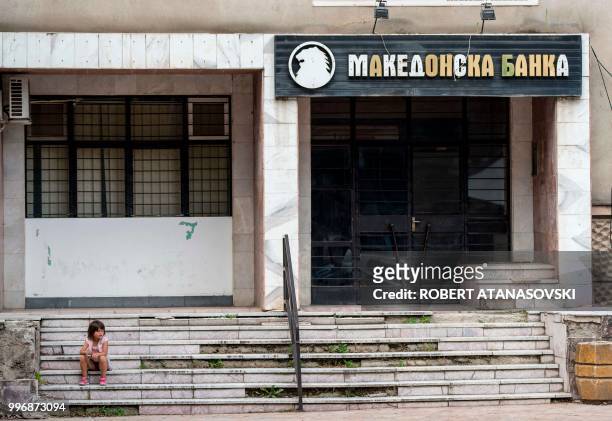 Girl sits on the stairs of a bank in Veles on June 12, 2018.