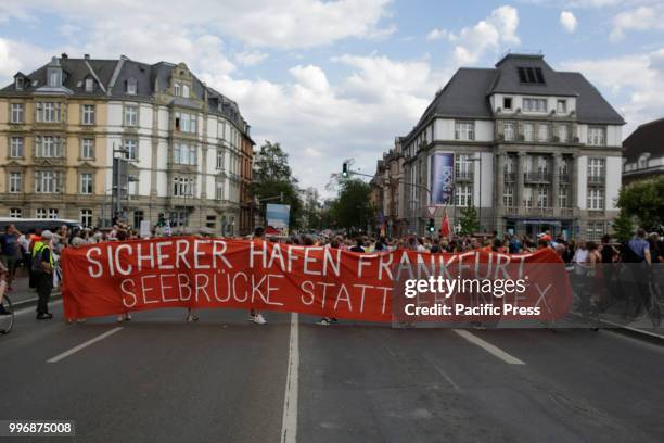 Protesters pose with banners and signs at the large Euro sign outside the former seat of the ECB. Around 800 protesters marched through Frankfurt to...