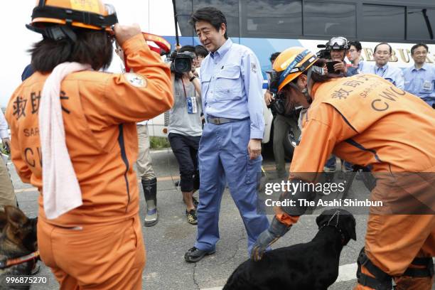 Prime Minister Shinzo Abe talks with rescue workers and dogs on July 11, 2018 in Kurashiki, Okayama, Japan. The death toll from the torrential rain...