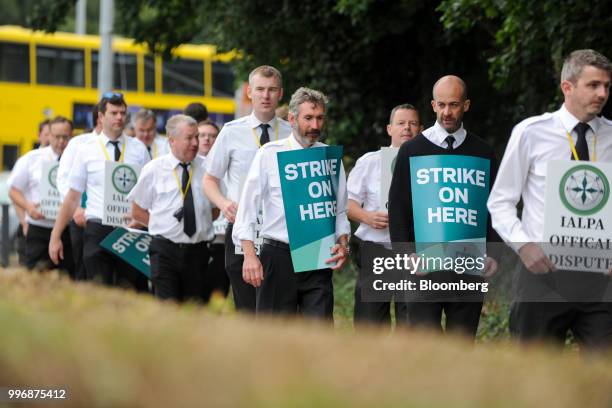 Pilots for Ryanair Holdings Plc and members of Irish Air Line Pilots' Association in Ireland's Forsa union carry signs as they march during a strike...