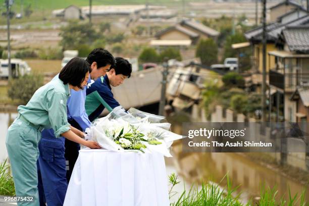 Prime Minister Shinzo Abe offer flowers at a hill he can see the submerged area on July 11, 2018 in Kurashiki, Okayama, Japan. The death toll from...