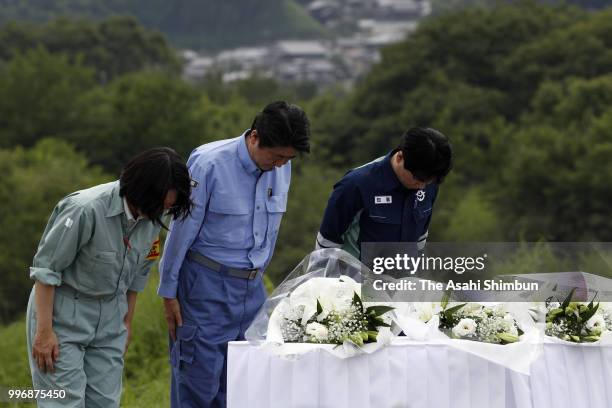 Prime Minister Shinzo Abe offer flowers at a hill he can see the submerged area on July 11, 2018 in Kurashiki, Okayama, Japan. The death toll from...