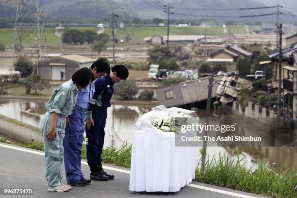 Prime Minister Shinzo Abe offer flowers at a hill he can see the submerged area on July 11, 2018 in Kurashiki, Okayama, Japan. The death toll from...