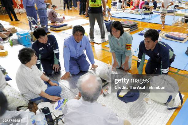 Japanese Prime Minister Shinzo Abe talks with evacuees at a gymnasium of the Okada Elementary School where people take shelter after the are was...