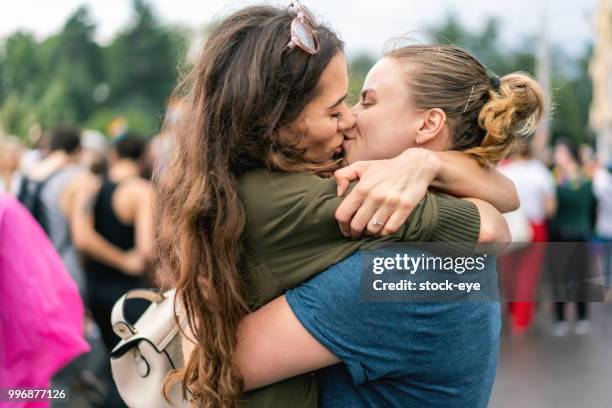 pareja mujer adulto joven en desfile del orgullo - gay couple kissing fotografías e imágenes de stock