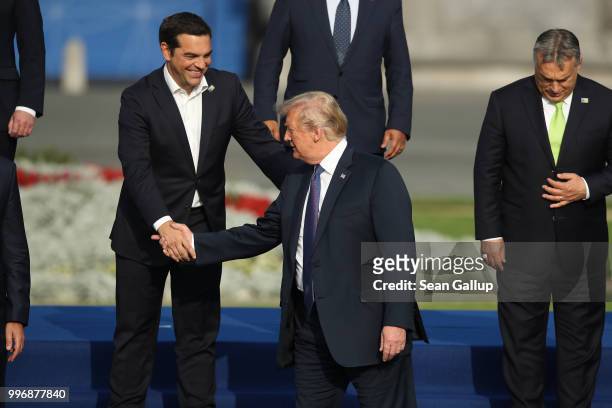 Greek Prime Minister Alexis Tsipras greets U.S. President Donald Trump prior to a group photo at the evening reception and dinner at the 2018 NATO...