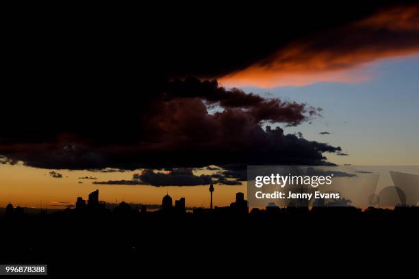 The sun sets over the Sydney skyline on July 12, 2018 in Sydney, Australia. The dramatic skies were caused by showers and local thunder moving across...