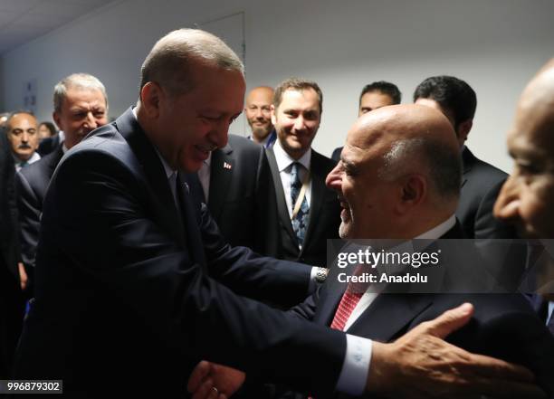 Turkish President Recep Tayyip Erdogan chats with Iraqi Prime Minister Haider al-Abadi as he arrives to attend the 3rd session of Heads of State and...