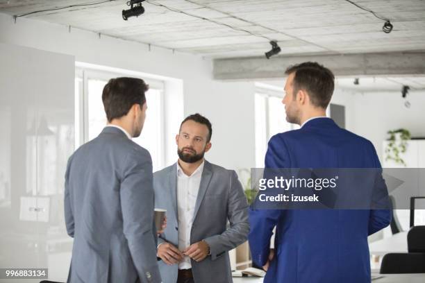 uomini d'affari che discutono durante la pausa caffè - izusek foto e immagini stock