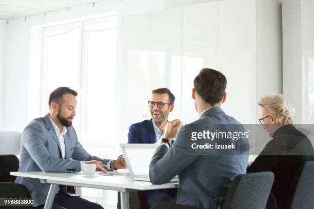 mature man laughing in meeting - izusek stock pictures, royalty-free photos & images