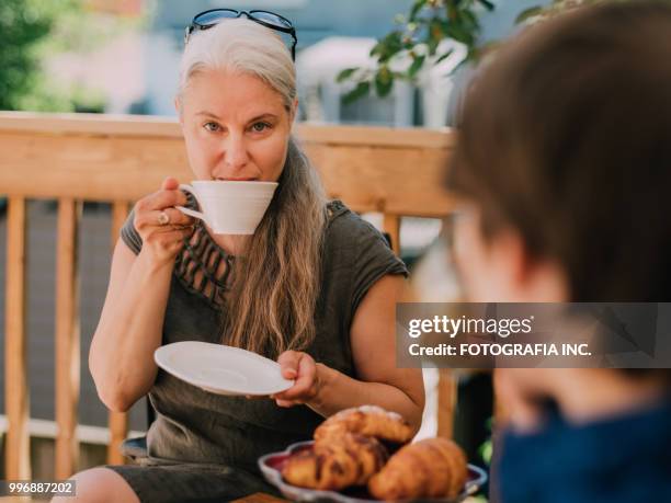 patio time with moter and son - shade45 stock pictures, royalty-free photos & images