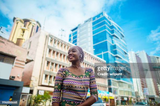 fröhlich zuversichtlich afrikanische mädchen im stadtzentrum - dar es salaam stock-fotos und bilder