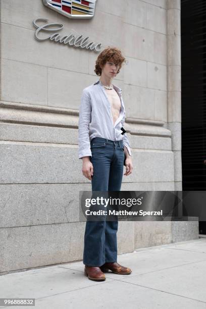 Model is seen on the street during Men's New York Fashion Week wearing grey shirt with blue jeans on July 11, 2018 in New York City.