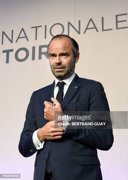 French Prime minister Edouard Philippe adjusts his suit before the closing speech of the Conference des Territoires meeting in Paris on July 12, 2018...