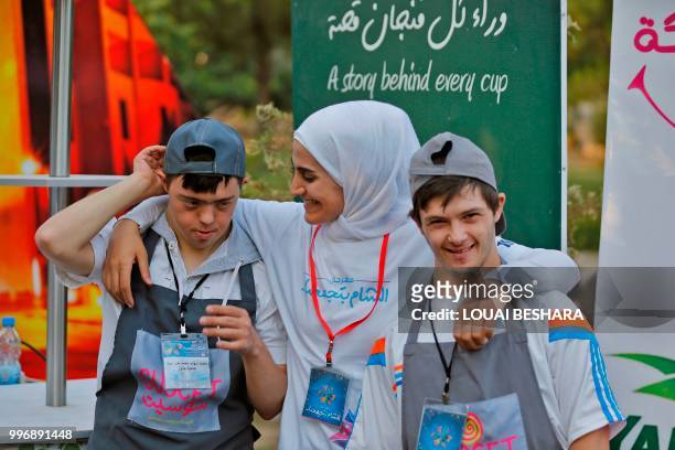 Syrian waiters with Down syndrome pose for a photohgraph as they work at the Sucet coffee shop during the "Sham gathers us" festival in Damascus on...