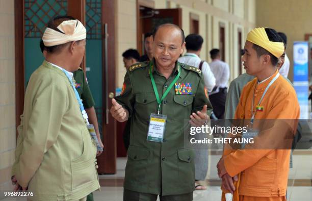 Member of Myanmar's military chats with members of the country's ethnic community outside a meeting room on the second day of the third session of...