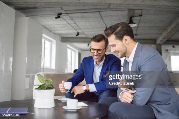 zakenman in discussie over een kopje koffie - izusek stockfoto's en -beelden