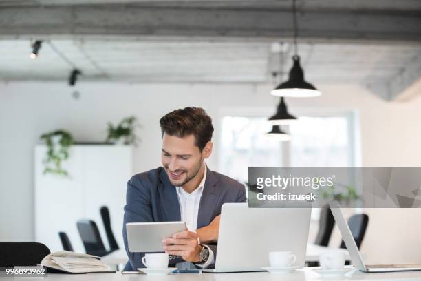 happy young businessman working in office - izusek stock pictures, royalty-free photos & images