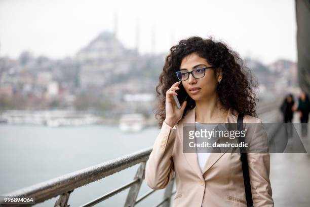 ung affärskvinna talar i telefon på gatan i istanbul, turkiet - turk telekom bildbanksfoton och bilder