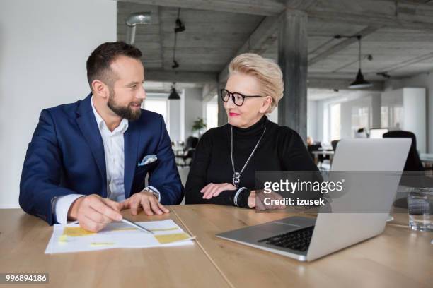 business partners discussing a project - izusek stock pictures, royalty-free photos & images