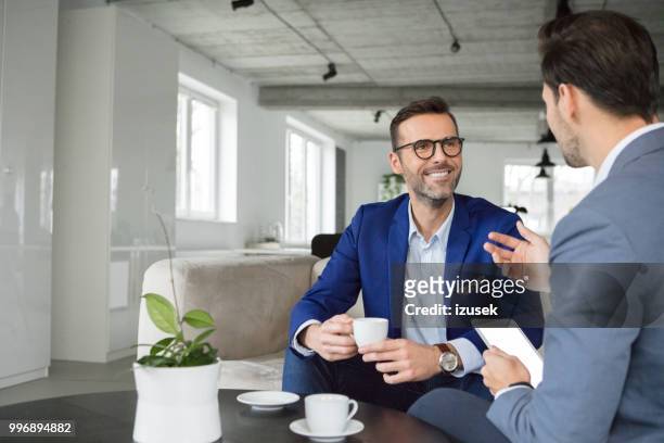 uomini d'affari che discutono in pausa - izusek foto e immagini stock