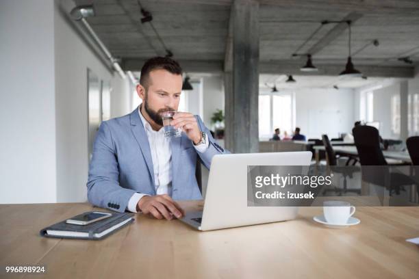 hombre de negocios ocupado trabajando en ordenador portátil - izusek fotografías e imágenes de stock