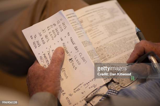 Visitor and potential customer looks at the catalogue during the 'Tattersalls' July Sale on July 11, 2018 in Newmarket, England. Founded in 1766...