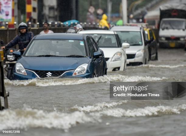 Vehicles wades through a water logged street as it rains at King Circle, on July 11, 2018 in Mumbai, India. Heavy rains made a comeback in Mumbai...