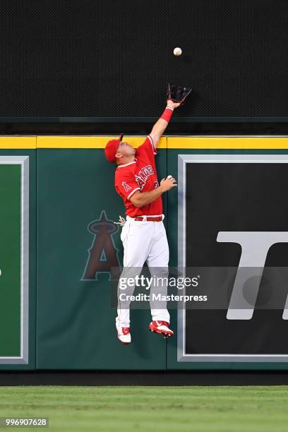 Mike Trout of the Los Angeles Angels of Anaheim is unable to hold onto a solo homerun hit by David Freitas of the Seattle Mariners during the MLB...