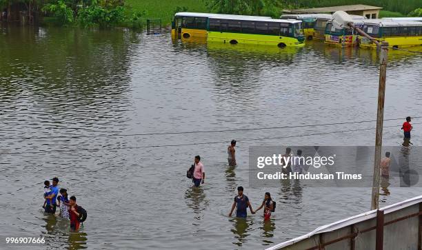 People wades through a water logged street at Nallasopara West Station Road, on July 11, 2018 in Mumbai, India. Heavy rains made a comeback in Mumbai...