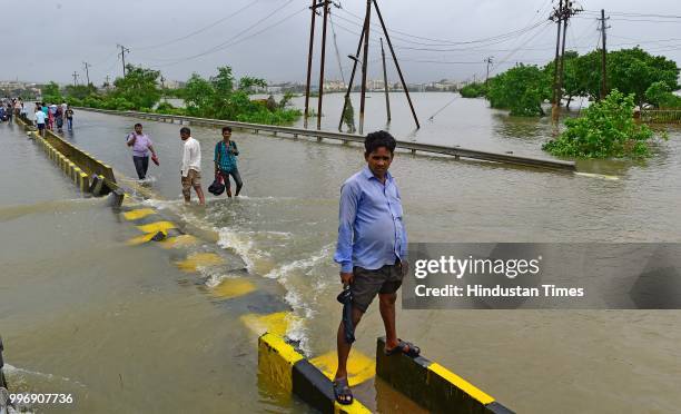 People wades through a water logged street at Ambadi Road Vasai East, on July 11, 2018 in Mumbai, India. Heavy rains made a comeback in Mumbai...