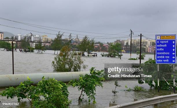 People wades through a water logged street at Ambadi Road Vasai East, on July 11, 2018 in Mumbai, India. Heavy rains made a comeback in Mumbai...