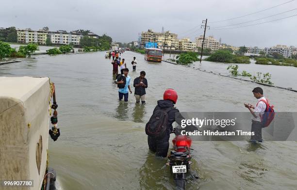 People wades through a water logged street at Ambadi Road Vasai East, on July 11, 2018 in Mumbai, India. Heavy rains made a comeback in Mumbai...