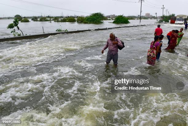 People wades through a water logged street at Ambadi Road Vasai East, on July 11, 2018 in Mumbai, India. Heavy rains made a comeback in Mumbai...