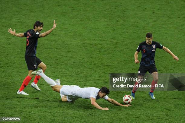 Harry Maguire of England is brought down by Andrej Kramic and Vedran Corluka of Croatia during the 2018 FIFA World Cup Russia Semi Final match...