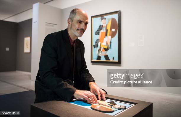 Dpatop - Reiner Delgado, social referent of the German Association for the Blind and Visually Impaired , touches a model of the painting 'Synthetic...