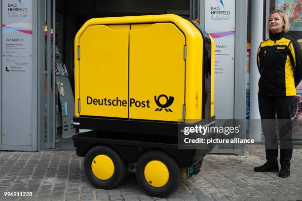 Postwoman Cindy Rexrodt with a "PostBOT" robot for postal carriers outside an office in Bad Hersfeld, Germany, 4 October 2017. Photo: Swen...