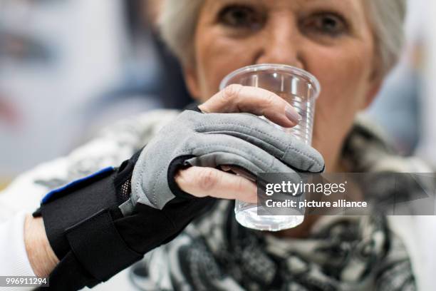 Model Wildtraut holding a cup with a bionic SEM hand at the REHACARE trade fair in Duesseldorf, Germany, 4 October 2017. The REHACARE trade fair for...