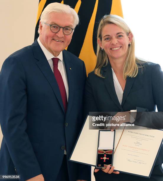 German President Frank-Walter Steinmeier presents the Order of Merit of the Federal Republic of Germany to retired soccer player Nia Kuenzer to honor...