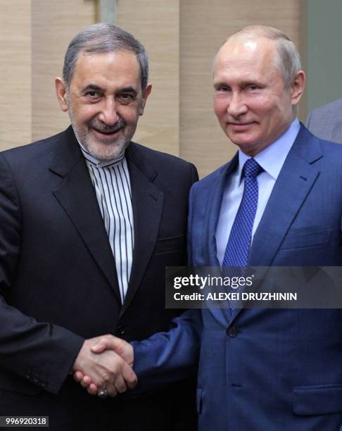 Russian President Vladimir Putin shakes hands with Ali Akbar Velayati, foreign policy advisor to Iran supreme leader, during a meeting at the...