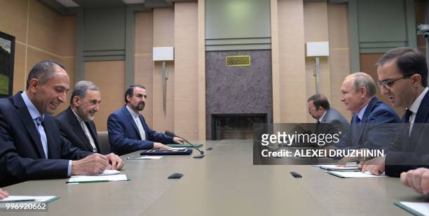 Russian President Vladimir Putin speaks with Ali Akbar Velayati , foreign policy advisor to Iran supreme leader, during a meeting at the Novo-Ogarevo...