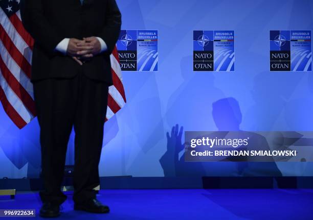 Secretary of State Mike Pompeo looks on as US President Donald Trump casts a shadow as he addresses a press conference on the second day of the North...