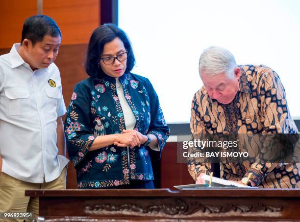 Indonesia's Finance Minister Sri Mulyani and Energy and Mineral Resources Minister Ignasius Jonan look on as CEO and vice chairman of...