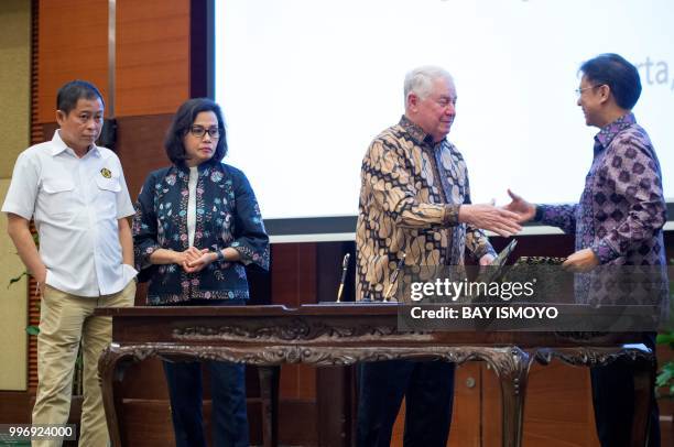 Indonesia's Energy and Mineral Resources Minister Ignasius Jonan and Finance Minister Sri Mulyani look on as CEO and vice chairman of...