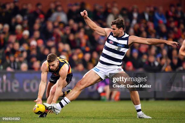Rory Laird of the Crows and Tom Hawkins of the Cats compete for the ball with during the round 17 AFL match between the Adelaide Crows and the...