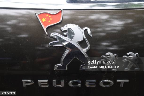 Peugeot logo is seen with a Chinese flag added on the back of a Peugeot car in Beijing on July 12, 2018.