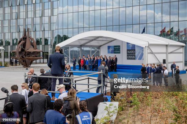 World leaders stand on a platform for a family photograph during the North Atlantic Treaty Organization summit at the military and political...