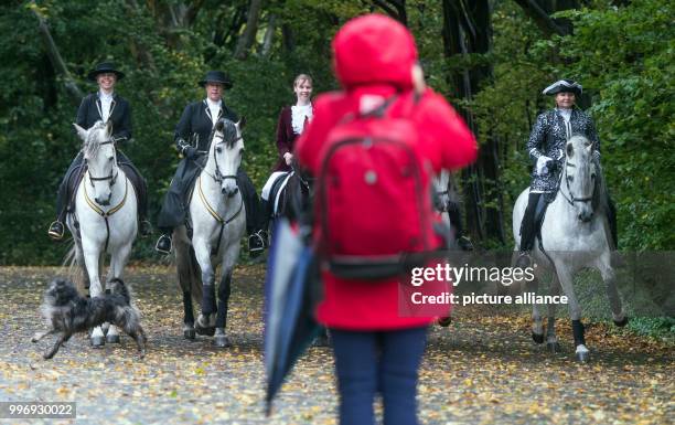 Woman in a raincoat photographs a group of Spanish riders as part of a photo session of the fair "Hund & Pferd" in Dortmund, Germany, 05 October...